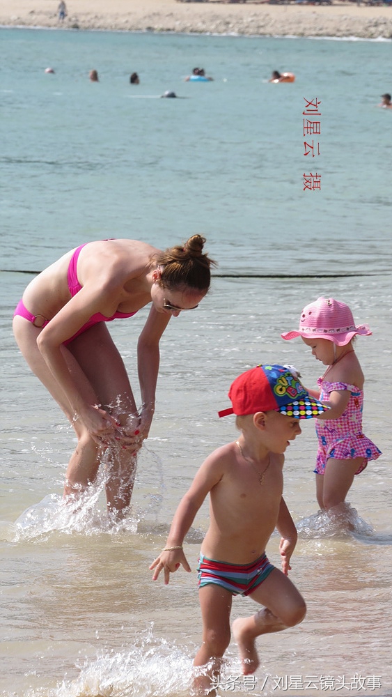 俄罗斯人三亚沙滩享受亲子日光浴好惬意,为人之母的洋妞有苗条的