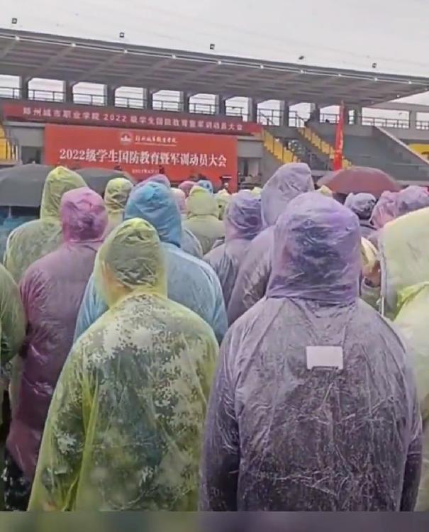 学生在雨中军训校领导在一旁打伞,雨中军训校领导躲雨